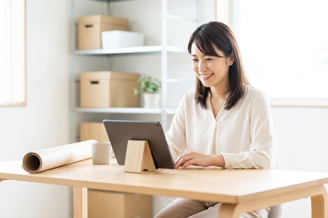 事務所でタブレットの図面を確認する女性スタッフ