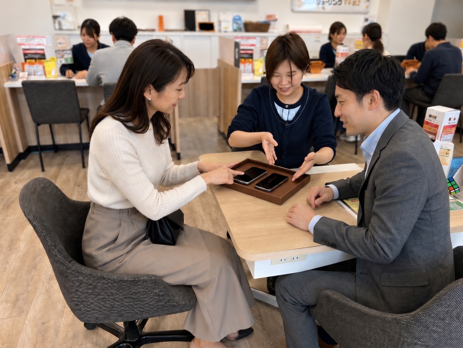 店舗でご家族と一緒にスマートフォンの料金を相談する様子